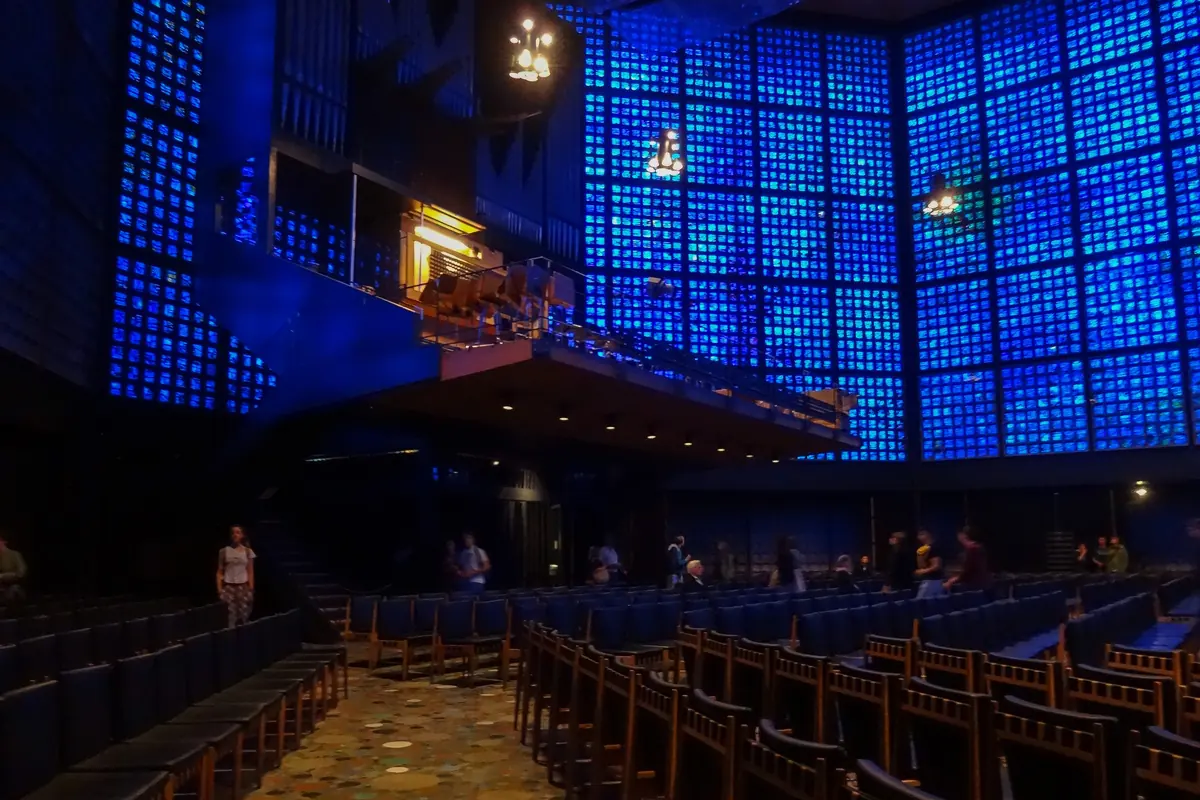 The organ gallery of the Memorial Church, a wide pipe case and console seen against deep blue glass walls and a dark wooden ceiling